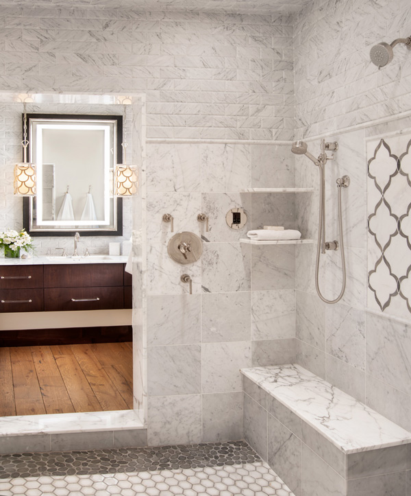 Interior bathroom tiled walk-in shower with mirror reflecting sink