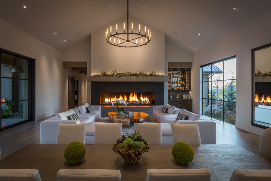 Living room with lit fireplace and couches surrounding
