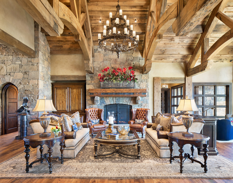 Living room stone fireplace with couches and seats surrounding